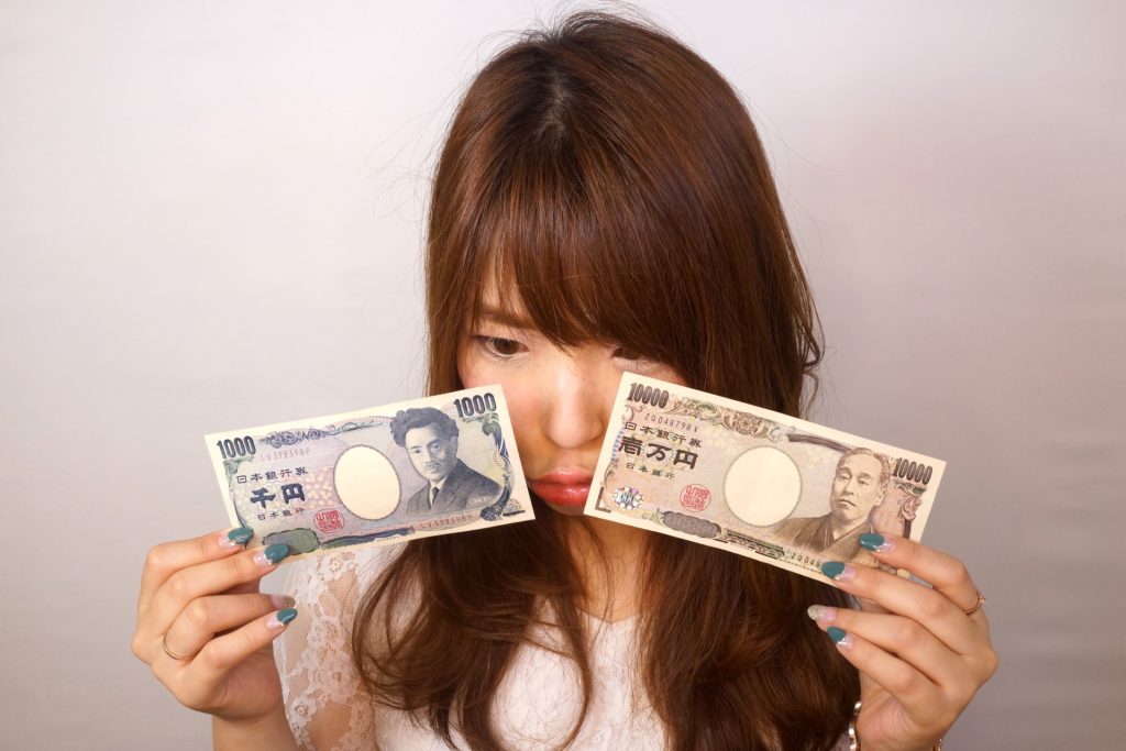 11000円を見つめる女性