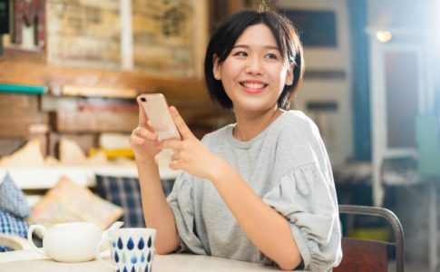 スマホを手に笑顔の女性